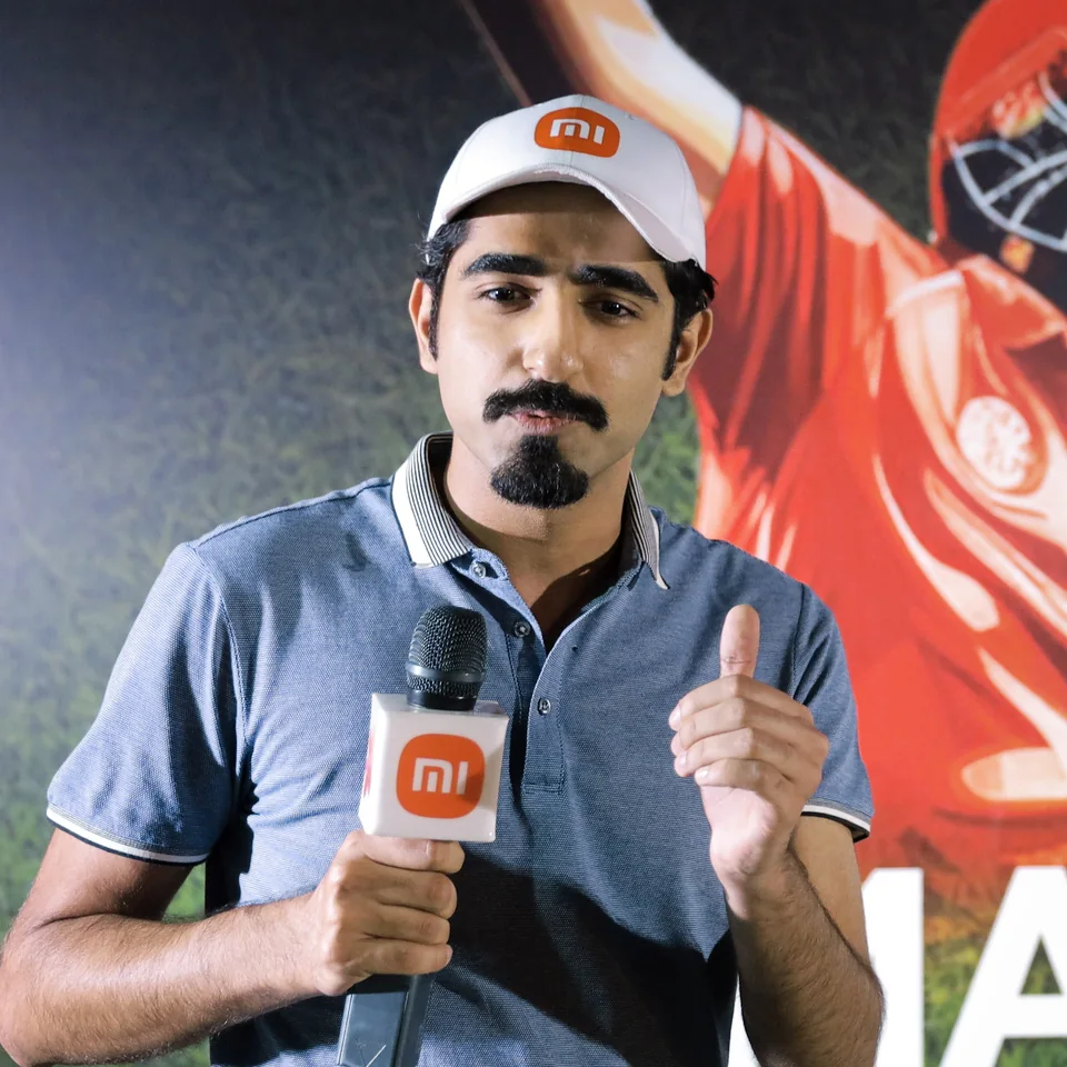 Naufil on stage at a Xiaomi event, holding a Mi microphone